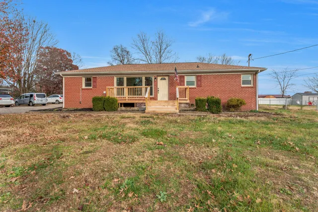 a view of a yard in front of a house with large tree
