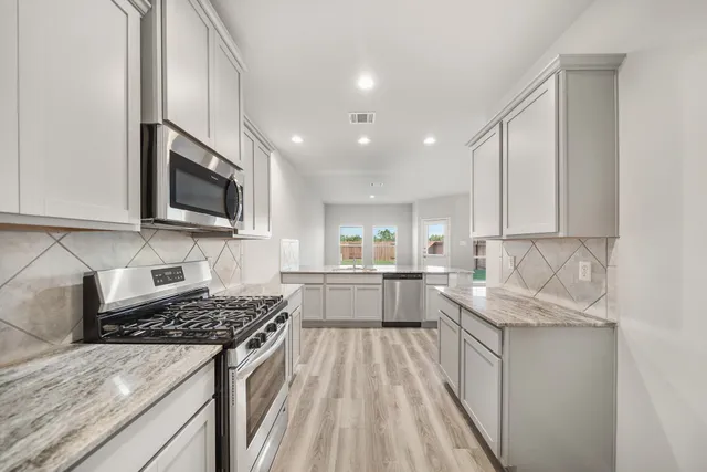 a kitchen with a sink stove top oven and cabinets