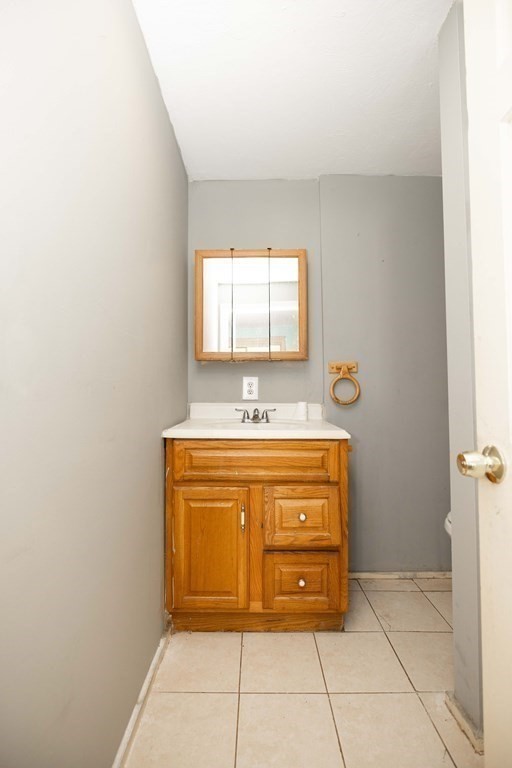 17 Montague Street, Unit B Worcester, MA 01603 - Photo 5 of 9 a bathroom with a granite countertop sink and a mirror