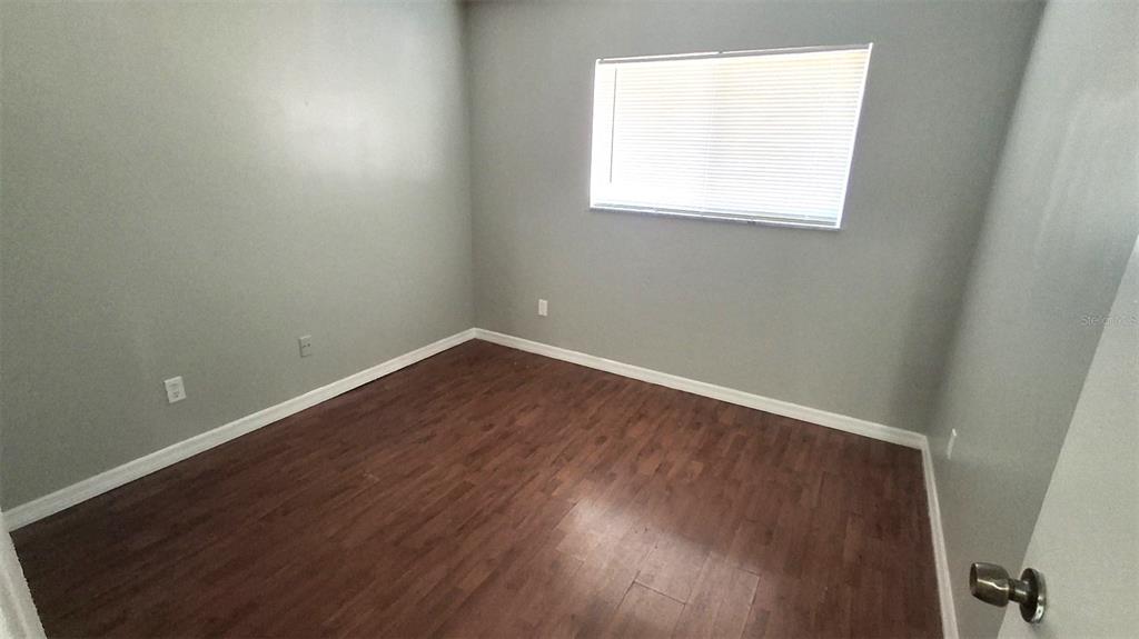4720 Lighthouse Circle Orlando, FL 32808 - Photo 11 of 16 an empty room with wooden floor and windows