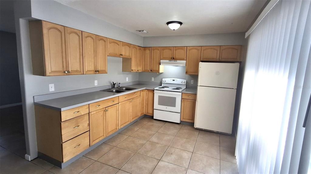 4720 Lighthouse Circle Orlando, FL 32808 - Photo 7 of 16 a kitchen with stainless steel appliances a refrigerator sink and cabinets