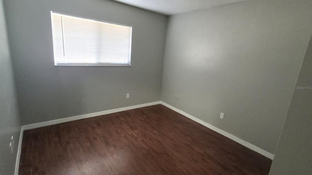 4720 Lighthouse Circle Orlando, FL 32808 - Photo 9 of 16 an empty room with wooden floor and windows