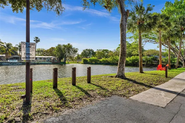 a view of a lake with a bench and trees around