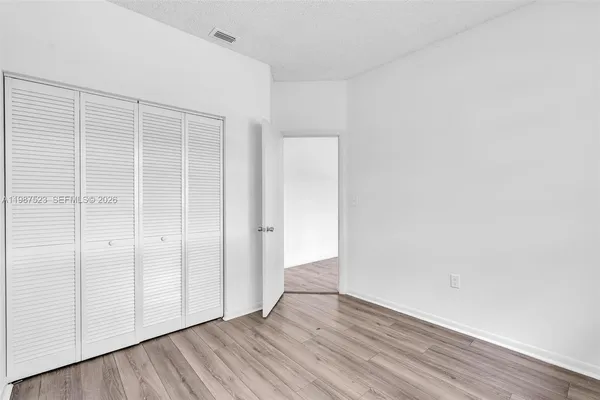 a view of a room with wooden floor and white walls
