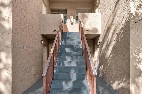 a view of a hallway with wooden floor and a flat screen tv