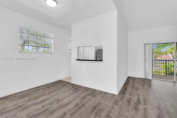 a view of a room with wooden floor and a flat screen tv