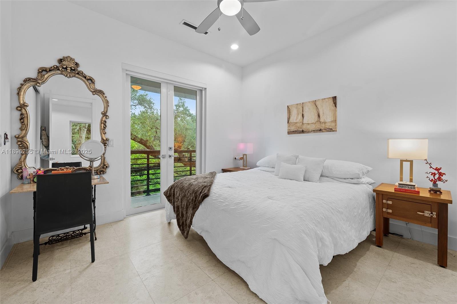 8923 Ludlam Road Pinecrest, FL 33156 - Photo 53 of 69 a bedroom with a bed and a chandelier