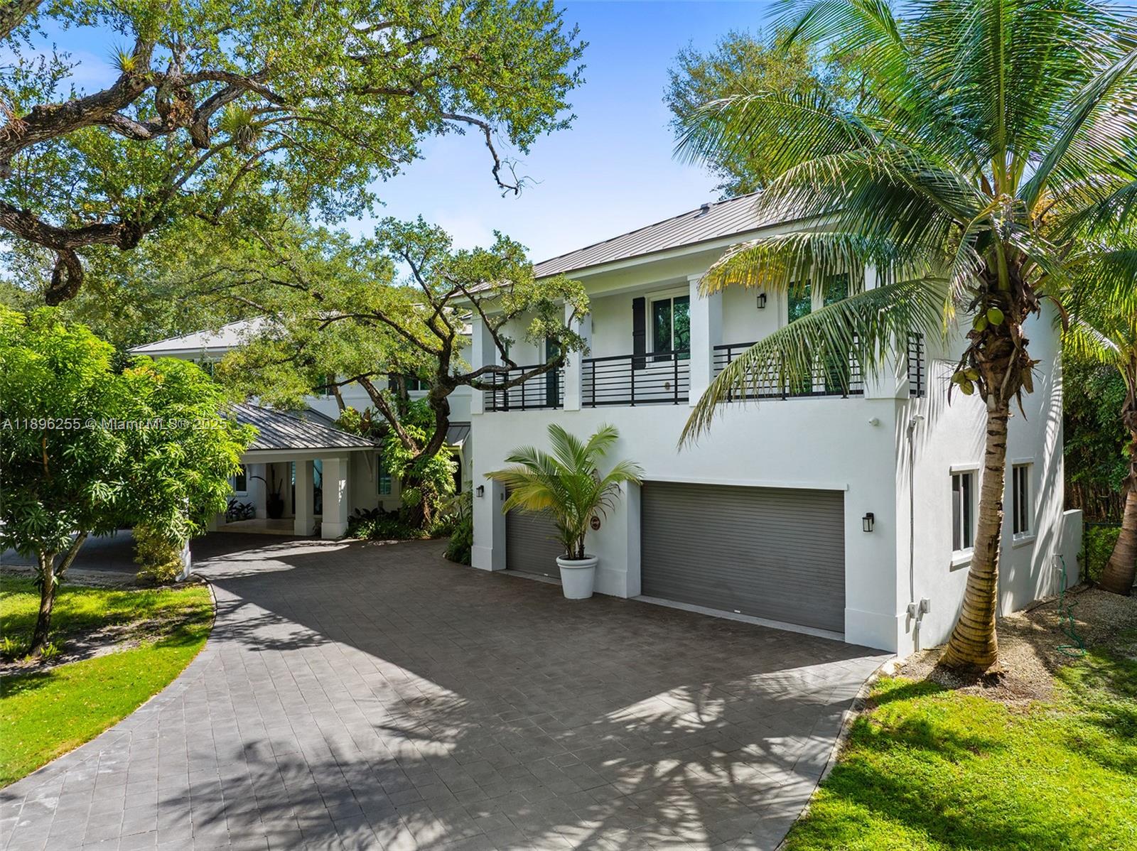8923 Ludlam Road Pinecrest, FL 33156 - Photo 61 of 69 a front view of a house with a yard and a garage
