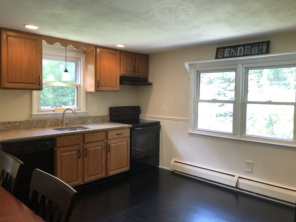 57 Middle Road Amesbury, MA 01913 - Photo 4 of 20 a kitchen with stainless steel appliances white cabinets a sink a stove a microwave a sink and a window