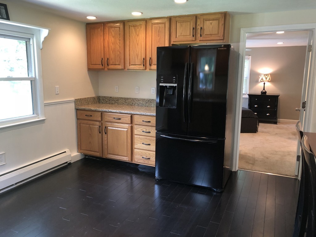 57 Middle Road Amesbury, MA 01913 - Photo 6 of 20 a kitchen with granite countertop a refrigerator and a stove top oven