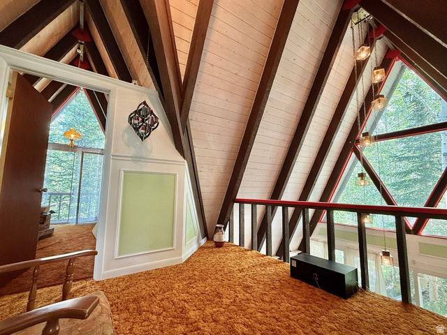 12498 East Wilderness Road Brighton, UT 84121 - Photo 37 of 40 Vaulted wood-paneled ceilings with exposed beams, triangular window framing, and rich orange shag carpeting
