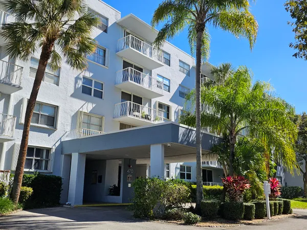 a front view of a multi story building with a yard