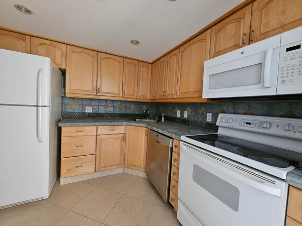 a kitchen with cabinets stainless steel appliances and sink