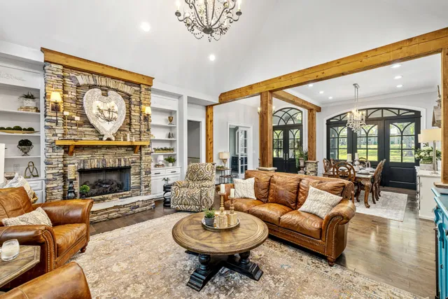 a living room with furniture a large window and a fireplace