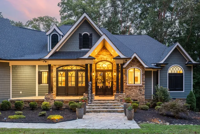 a view of a house with a big yard and large trees