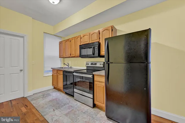 a kitchen with stainless steel appliances granite countertop a refrigerator and a stove