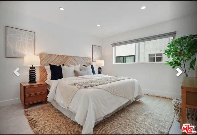 a bedroom with bed and a potted plant