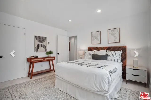 a bedroom with a white bed and a couch