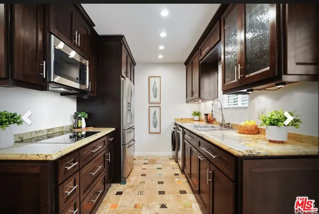 a kitchen with stainless steel appliances granite countertop a sink stove and refrigerator