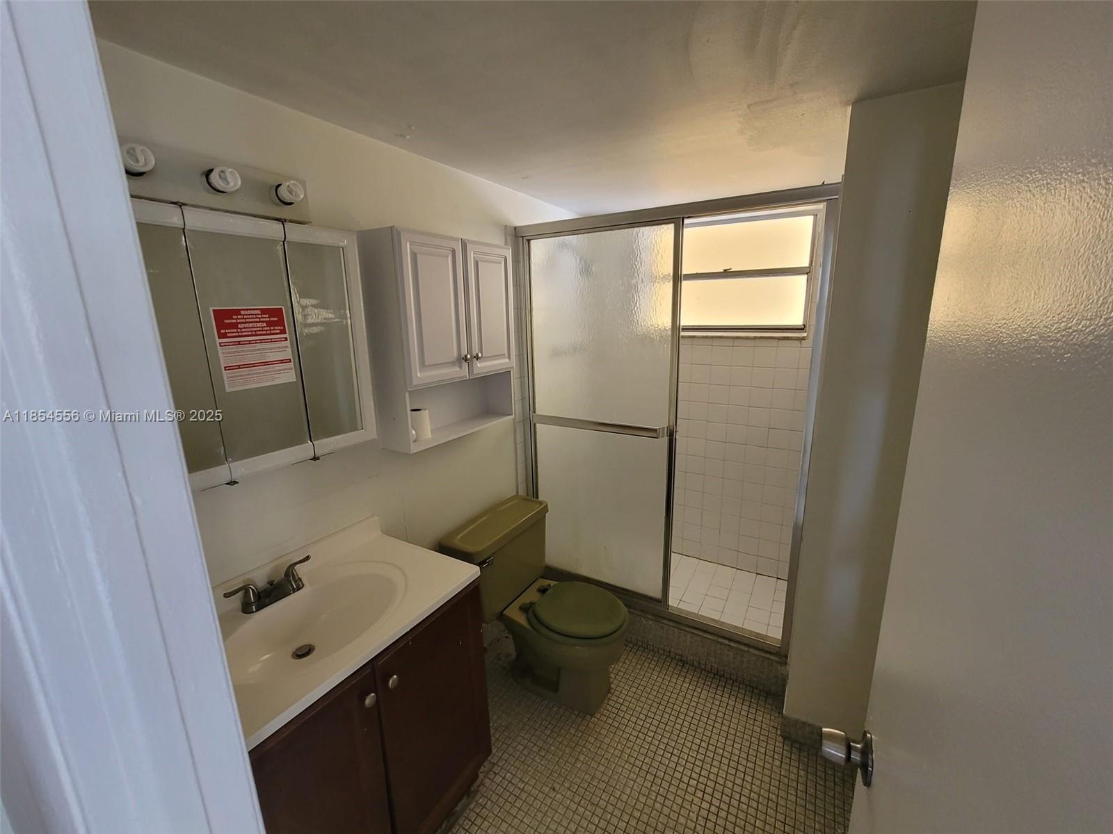 16400 Northeast 17th Avenue, Unit 206 North Miami Beach, FL 33162 - Photo 12 of 12 a bathroom with a sink a toilet and shower