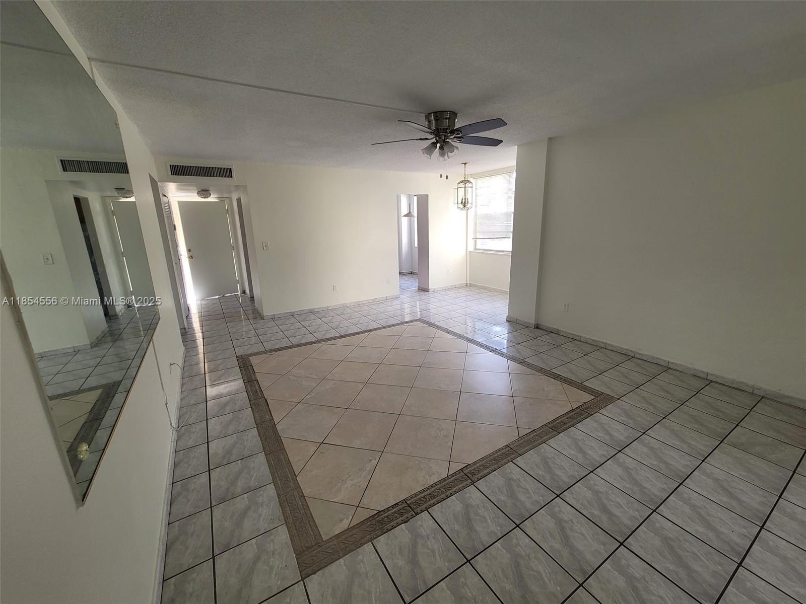 16400 Northeast 17th Avenue, Unit 206 North Miami Beach, FL 33162 - Photo 2 of 12 an empty room with wooden floor and windows