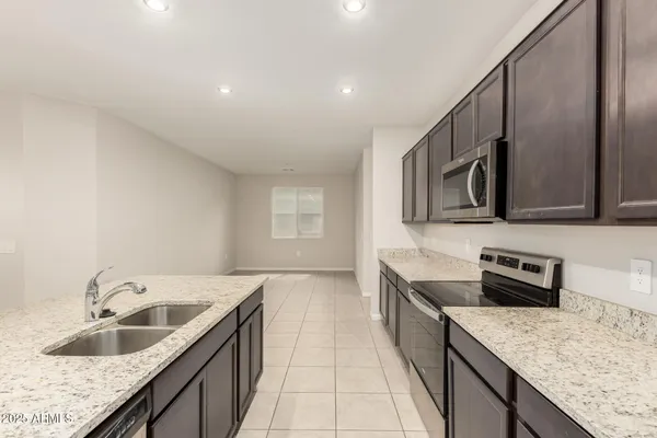 a kitchen with stainless steel appliances granite countertop a sink and a refrigerator