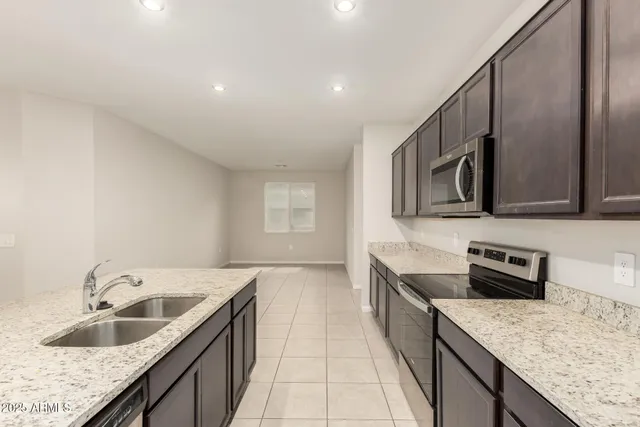 a kitchen with stainless steel appliances granite countertop a sink and a refrigerator