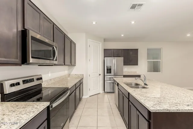 a kitchen with stainless steel appliances granite countertop a sink stove and refrigerator