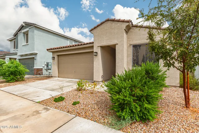 a view of a house with a yard and potted plants