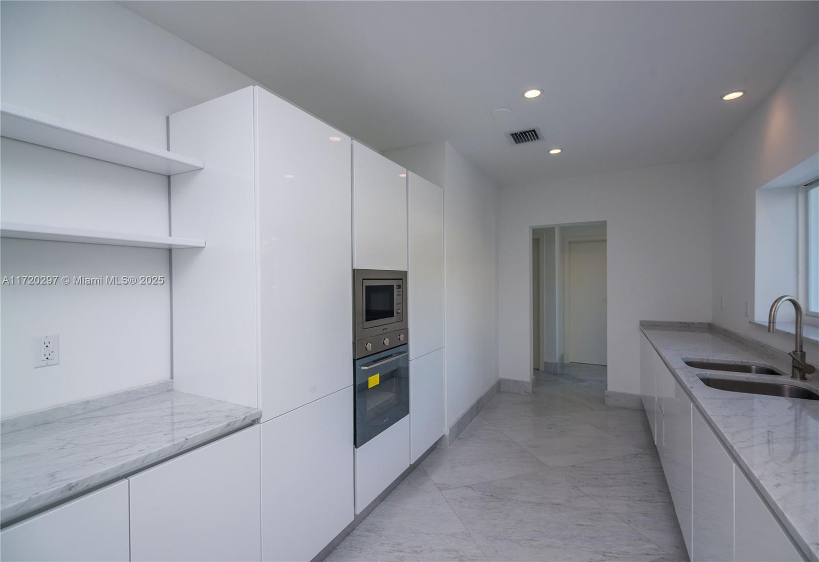 4500 Alton Road Miami Beach, FL 33140 - Photo 18 of 32 a kitchen with stainless steel appliances granite countertop a refrigerator and a stove