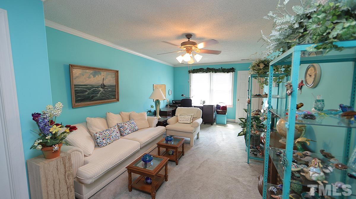 7943 Footman Way Raleigh, NC 27615 - Photo 7 of 11 a living room with furniture flowers and a chandelier