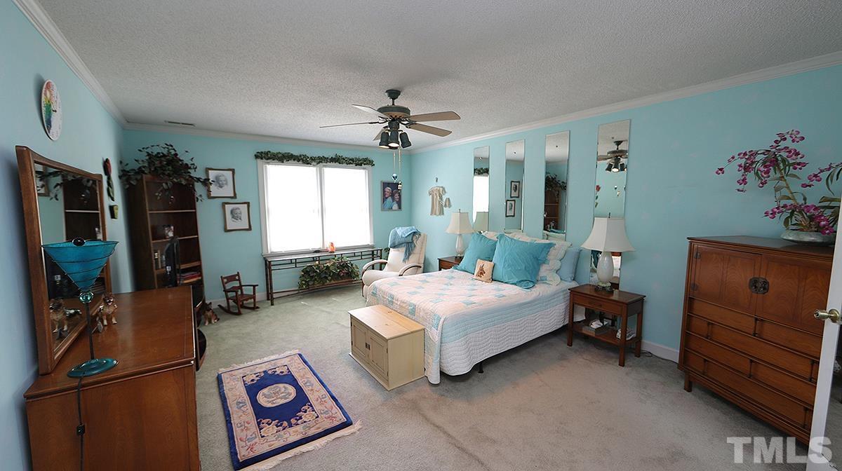 7943 Footman Way Raleigh, NC 27615 - Photo 8 of 11 a spacious bedroom with a bed and a dresser in it