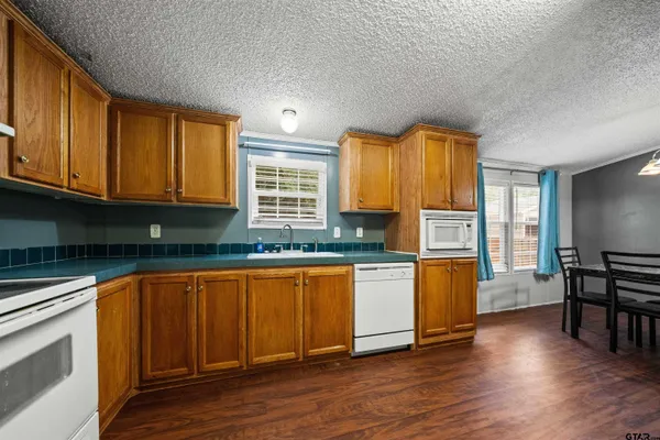 a kitchen with stainless steel appliances granite countertop a refrigerator oven a stove with wooden floors