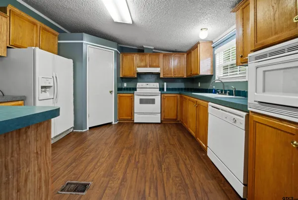 a kitchen with granite countertop wooden floors stainless steel appliances and sink