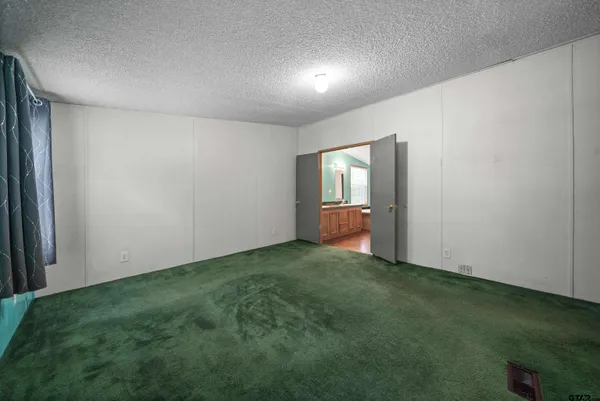 a view of a room with wooden floor and a bathroom