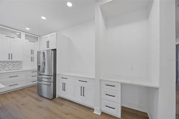 a kitchen with white cabinets and stainless steel appliances