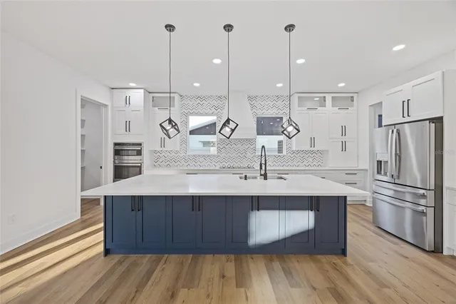 a kitchen with kitchen island a sink stainless steel appliances and cabinets