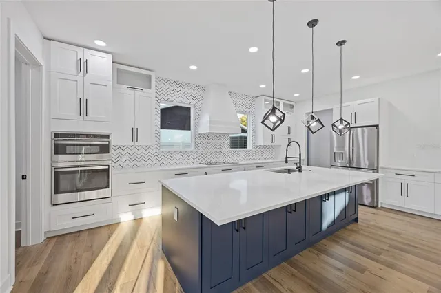 a kitchen with kitchen island a sink stainless steel appliances and cabinets