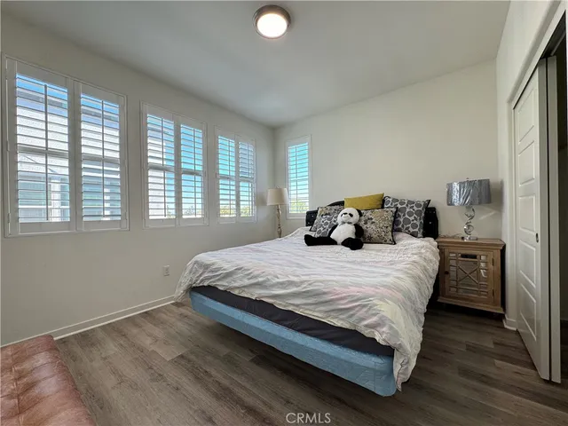 a bedroom with a bed and wooden floor