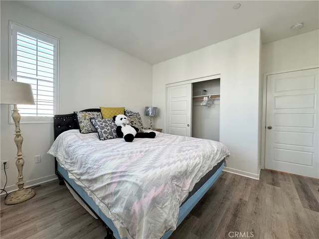 a large bed sitting in a bedroom next to a window and a wooden floor