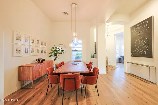 a dining room with furniture a chandelier and wooden floor