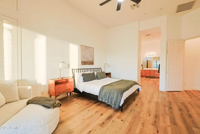 a bedroom with a bed and wooden floor