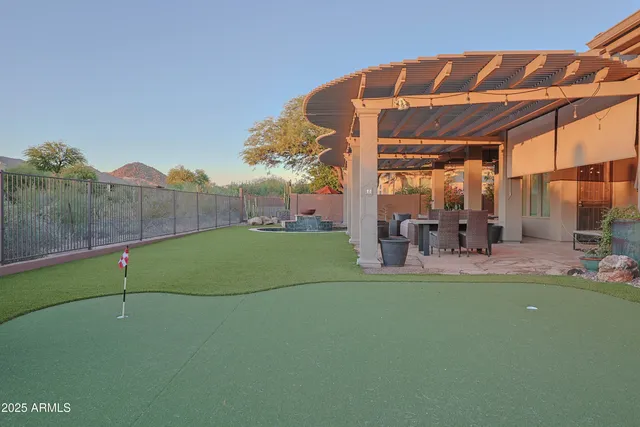 a view of a backyard with table and chairs under an umbrella