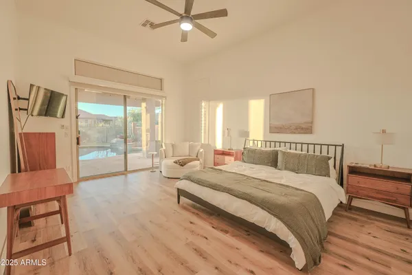 a spacious bedroom with a bed a couch and a large window