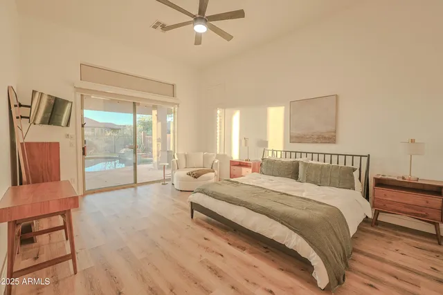 a spacious bedroom with a bed a couch and a large window