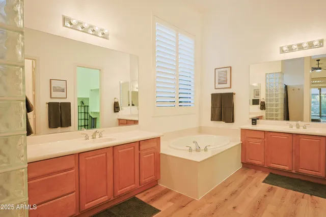 a bathroom with a tub double vanity sink and mirror