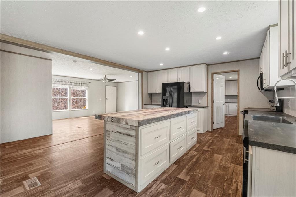 15 Rutledge Road Seale, AL 36875 - Photo 10 of 25 Kitchen with butcher block countertops, white cabinets, dark wood finished floors, ceiling fan, and a center island