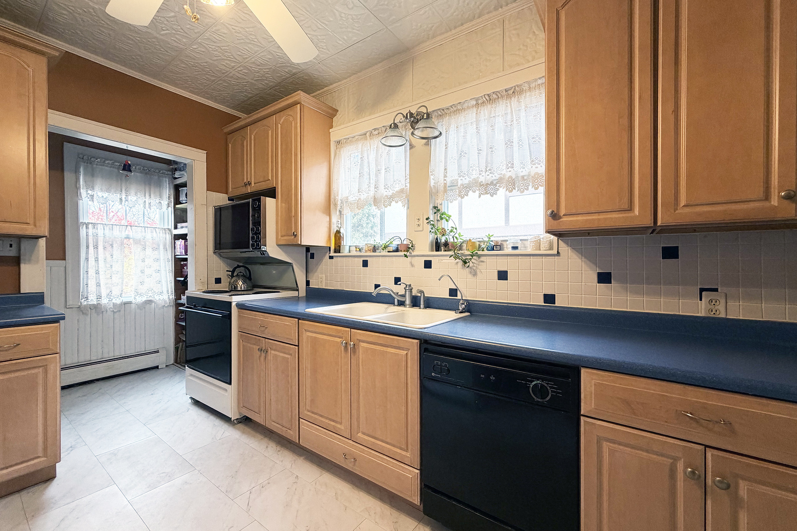 118 South William Street Mount Prospect, IL 60056 - Photo 13 of 24 a kitchen with stainless steel appliances sink a window and white cabinets