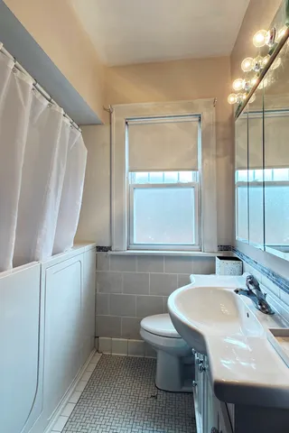 a bathroom with a sink a toilet and a mirror