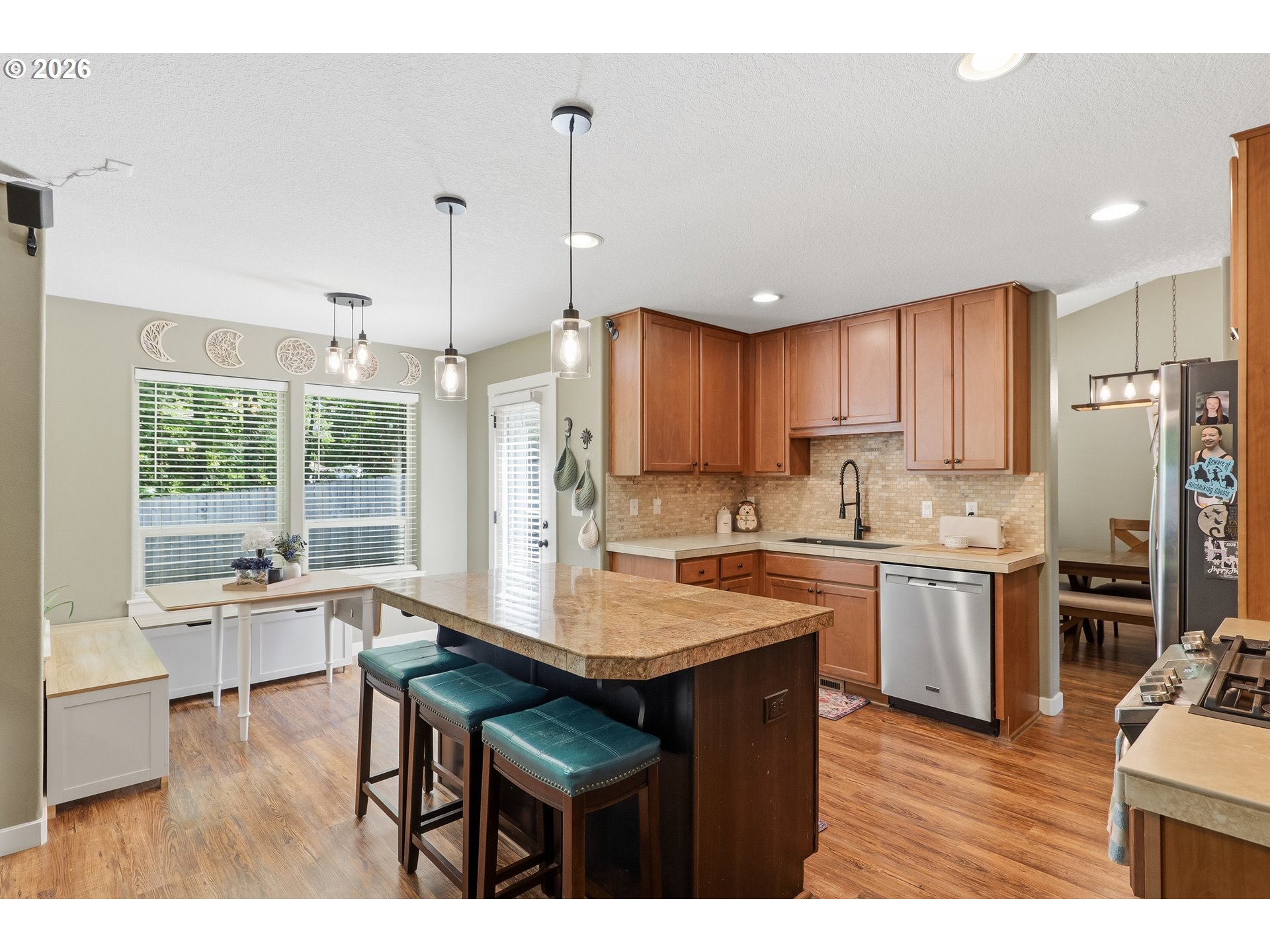 17376 Aubin Street Sandy, OR 97055 - Photo 9 of 21 a kitchen with a stove a refrigerator a sink dishwasher with a dining table and chairs